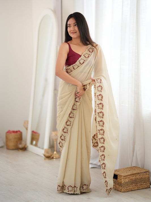 Woman wearing off white georgette saree with ornamented surface design and maroon blouse
