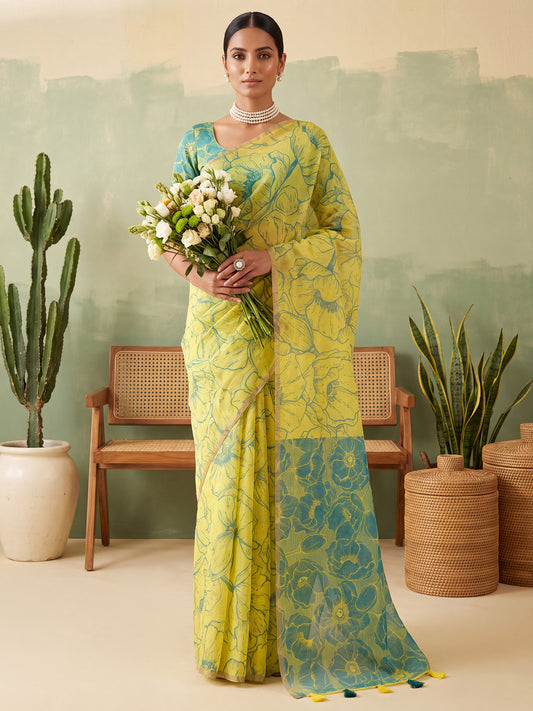 Woman wearing yellow cotton linen saree with all-over floral design and teal green blouse