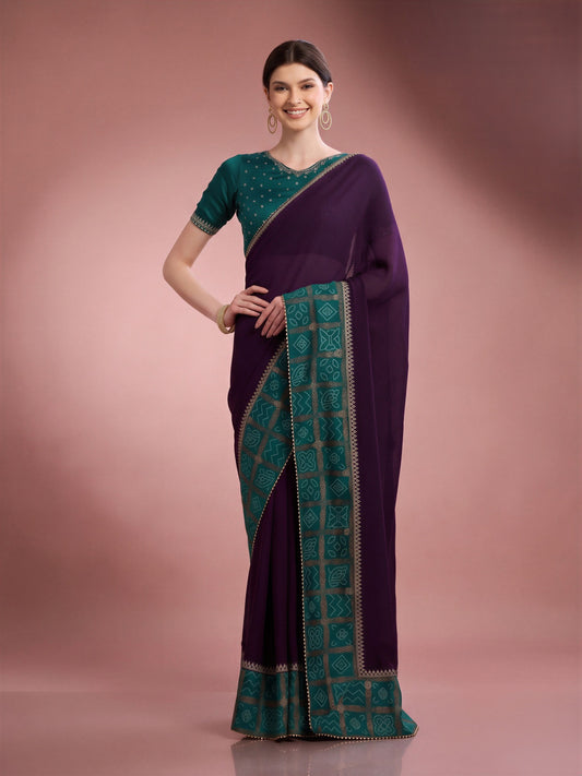 Woman wearing purple vichitra silk saree with bandhani tie-dye dot work and teal blue blouse
