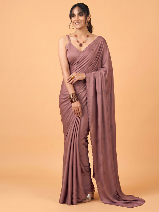 Woman wearing mauve satin silk saree with ornamented surface design and mauve blouse