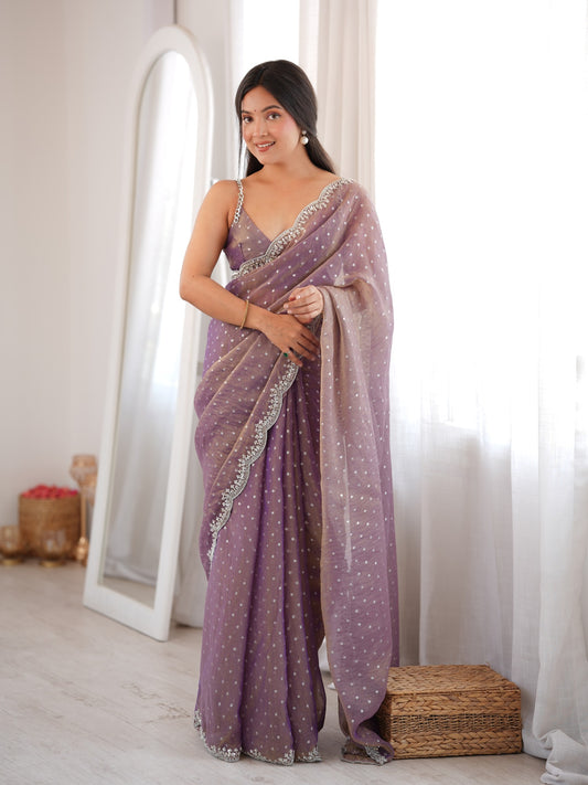 Woman wearing lavender silk blend saree with ornamented surface design and lavender blouse