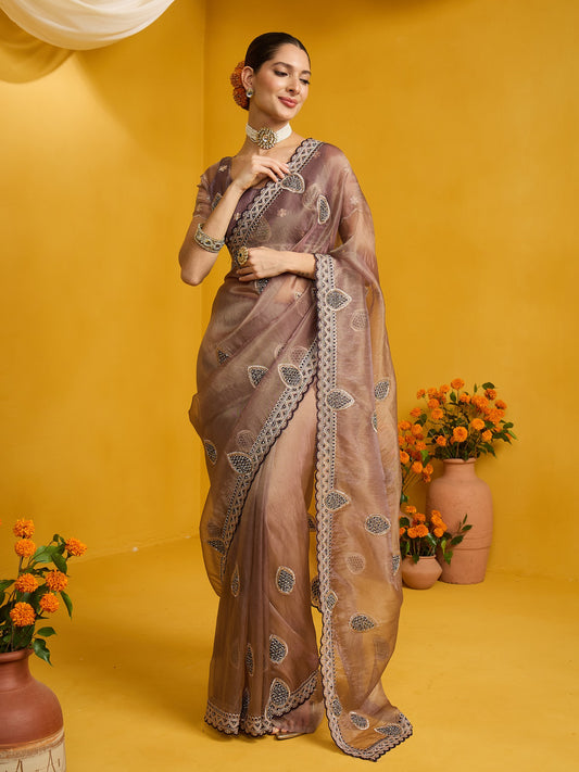 Woman wearing rose gold organza saree with ornamented surface design and rose gold blouse