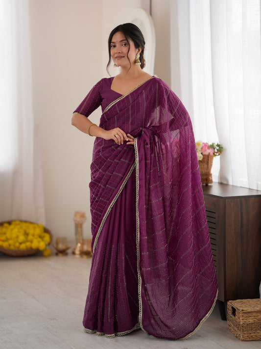 Woman wearing purple georgette saree with ornamented surface design and purple blouse