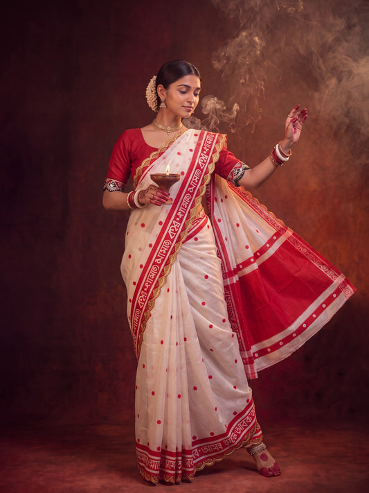 Woman wearing white cotton saree with traditional indian motif work and red blouse