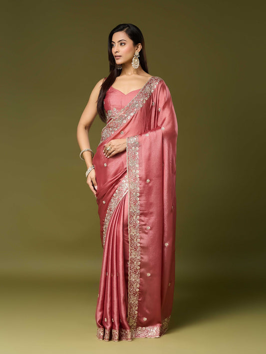 Woman wearing peach chinnon saree with embroidered motif work and peach blouse