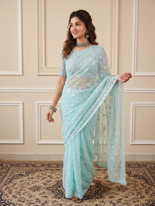 Woman wearing light blue georgette saree with ornamented surface design and light blue blouse