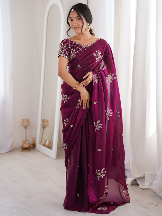Woman wearing purple satin saree with ornamented surface design and purple blouse