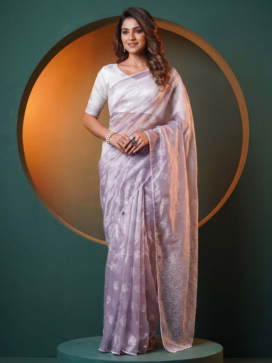 Woman wearing lavender organza saree with embroidered motif work and white blouse