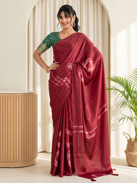 Woman wearing maroon satin silk saree with tie-and-dye resist pattern and green blouse