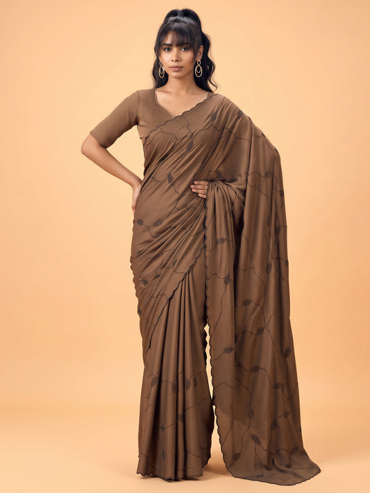 Woman wearing coffee brown satin silk saree with ornamented surface design and coffee brown blouse