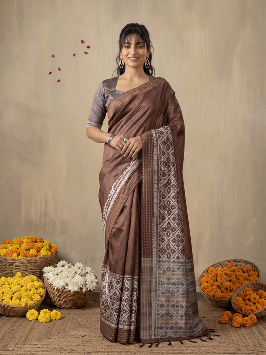 Woman wearing brown silk cotton saree with ikat resist-dyed pattern and grey blouse
