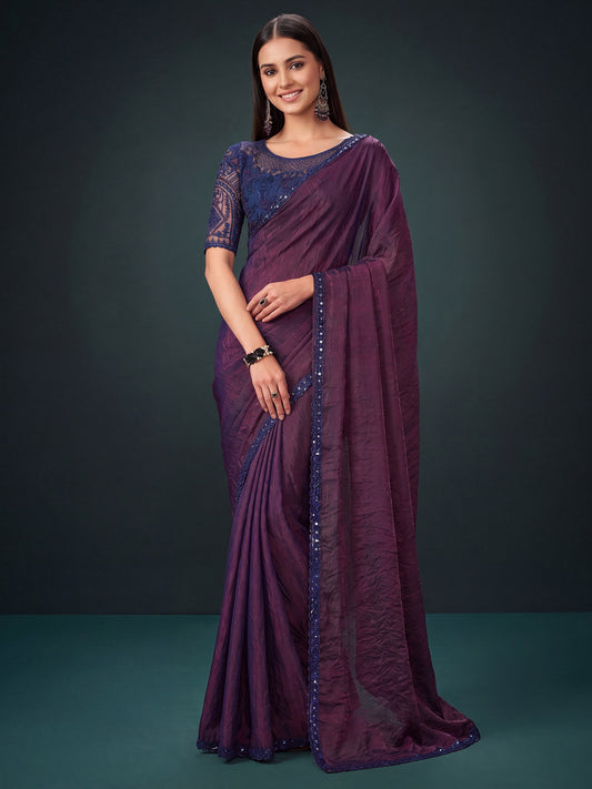 Woman wearing wine georgette saree with ornamented surface design and blue blouse