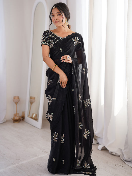 Woman wearing black satin saree with ornamented surface design and black blouse