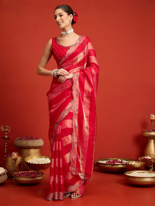 Woman wearing pink satin silk saree with ornamented surface design and pink blouse