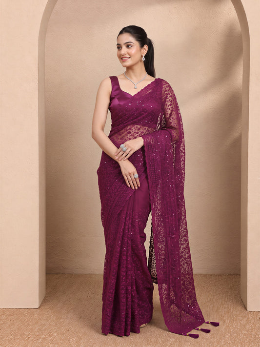 Woman wearing black net saree with embroidered motif work and black blouse