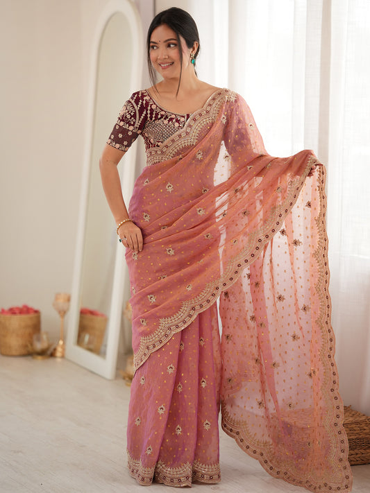 Woman wearing peach silk blend saree with ornamented surface design and wine blouse