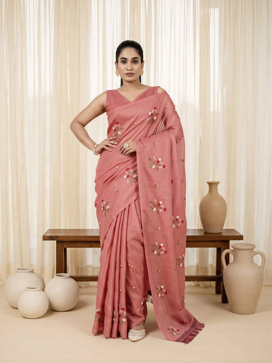 Woman wearing peach kota doria cotton saree with embroidered motif work and peach blouse