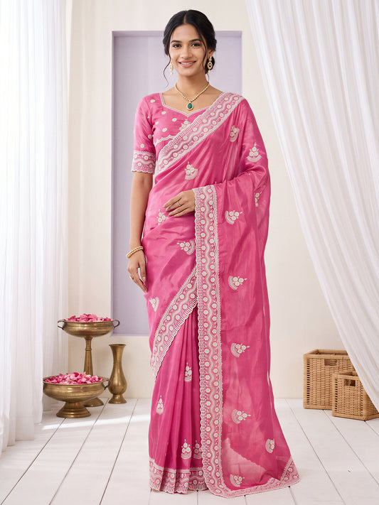 Woman wearing pink paper silk saree with ornamented surface design and pink blouse
