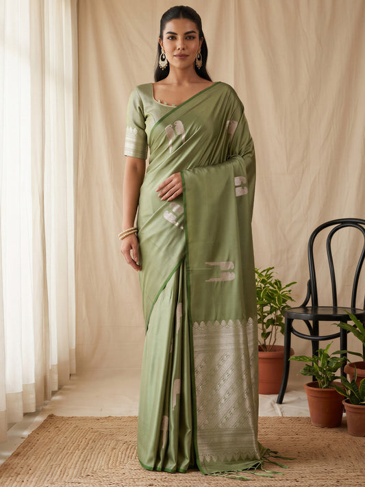 Woman wearing light green satin saree with botanical floral and leaf design and light green blouse