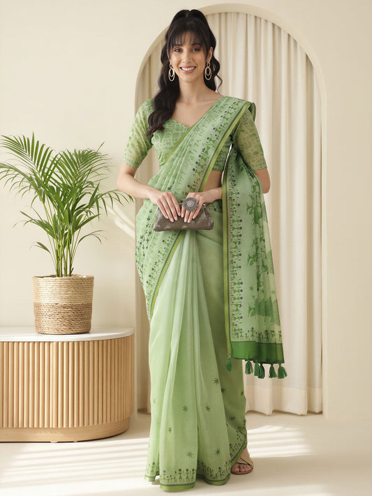 Woman wearing light green cotton linen saree with warli folk-art figures and light green blouse