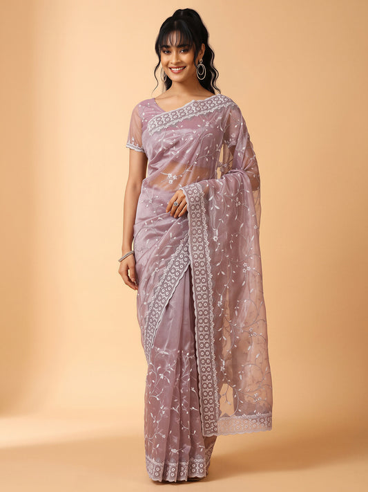 Woman wearing purple organza saree with ornamented surface design and purple blouse
