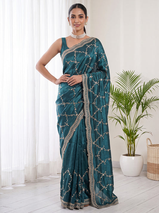 Woman wearing teal green satin saree with embroidered motif work and teal green blouse