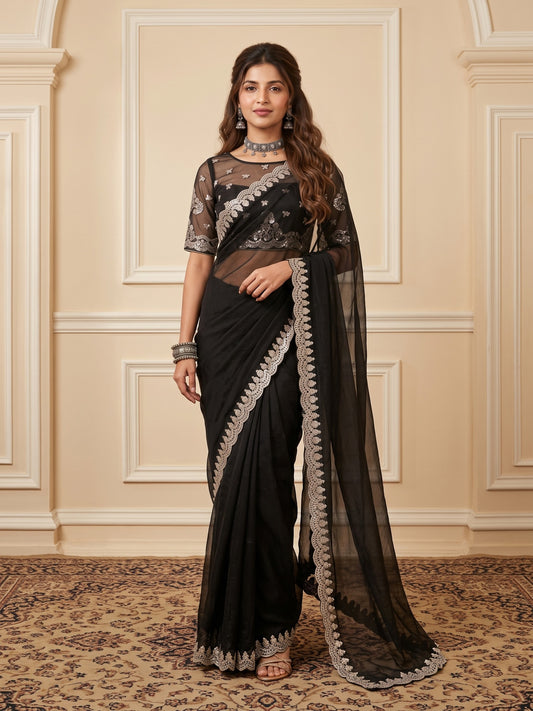 Woman wearing black satin saree with ornamented surface design and black blouse