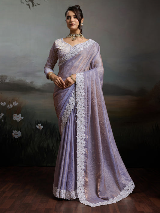 Woman wearing lavender satin silk saree with clean solid-tone finish and lavender blouse
