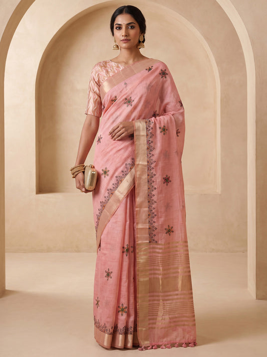 Woman wearing pink cotton linen saree with embroidered motif work and pink blouse