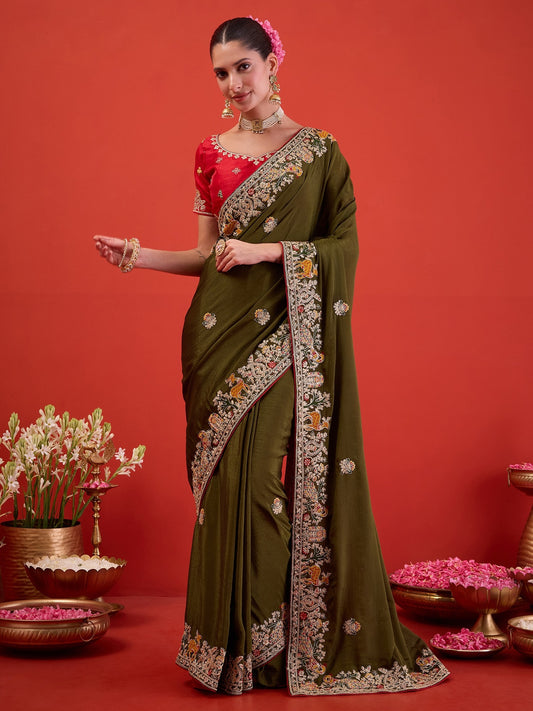 Woman wearing green silk blend saree with embroidered motif work and red blouse