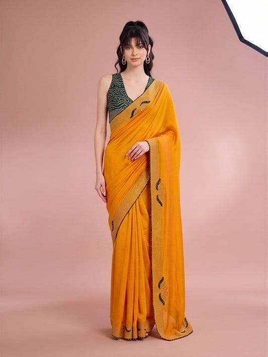 Woman wearing yellow vichitra silk saree with ornamented surface design and green blouse