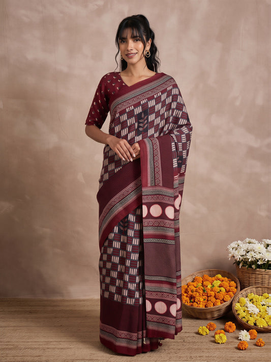 Woman wearing maroon viscose silk saree with traditional indian motif work and maroon blouse