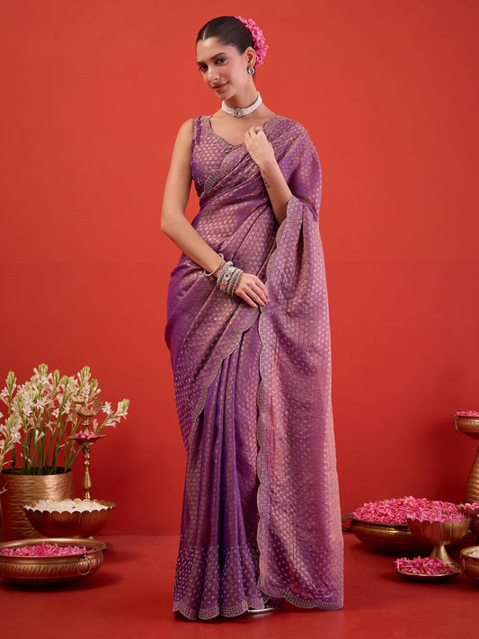 Woman wearing lavender satin saree with ornamented surface design and lavender blouse