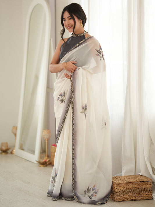 Woman wearing off white satin saree with all-over floral design and black blouse