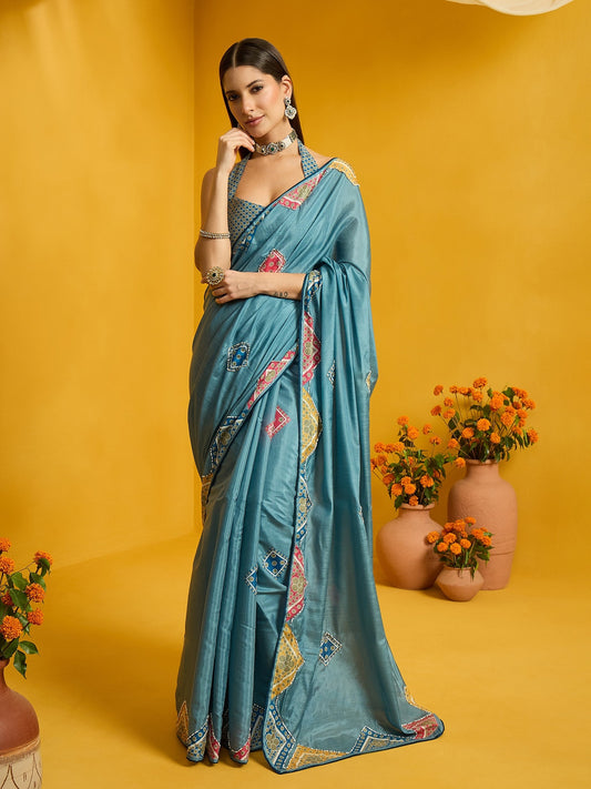Woman wearing teal blue silk cotton saree with traditional indian motif work and teal blue blouse