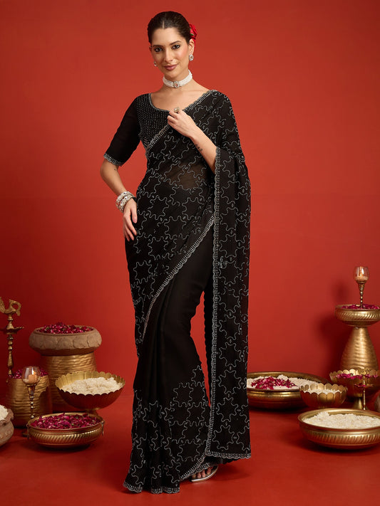 Woman wearing black chiffon saree with ornamented surface design and black blouse