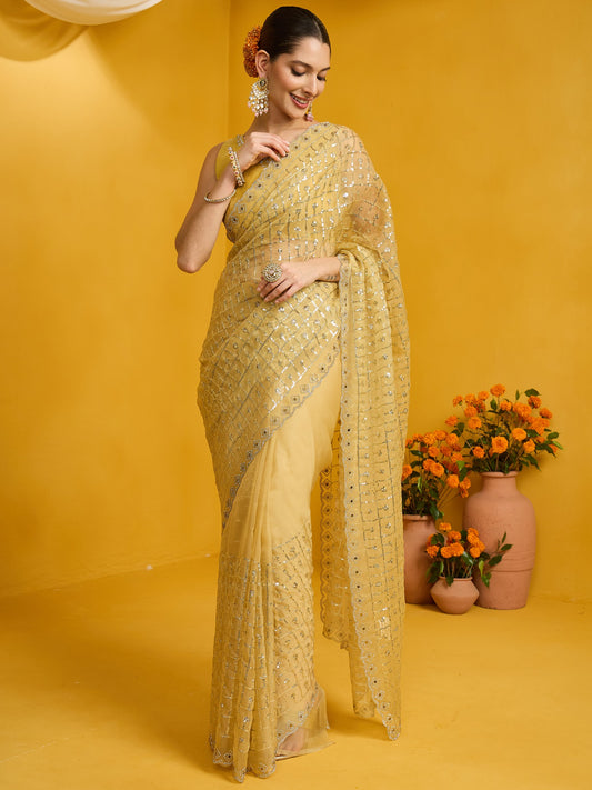Woman wearing yellow soft silk saree with ornamented surface design and yellow blouse