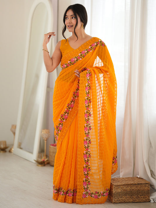 Woman wearing orange georgette saree with ornamented surface design and orange blouse