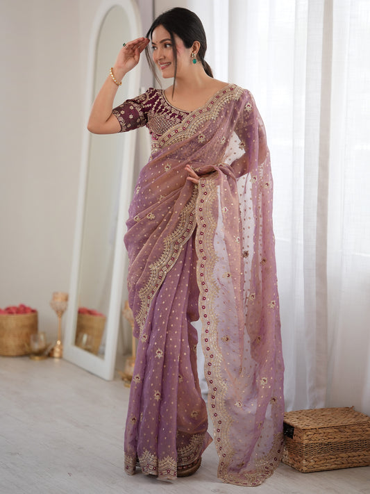 Woman wearing mauve silk blend saree with ornamented surface design and wine blouse