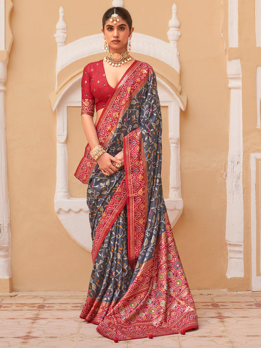 Woman wearing grey silk blend saree with ikat resist-dyed pattern and red blouse