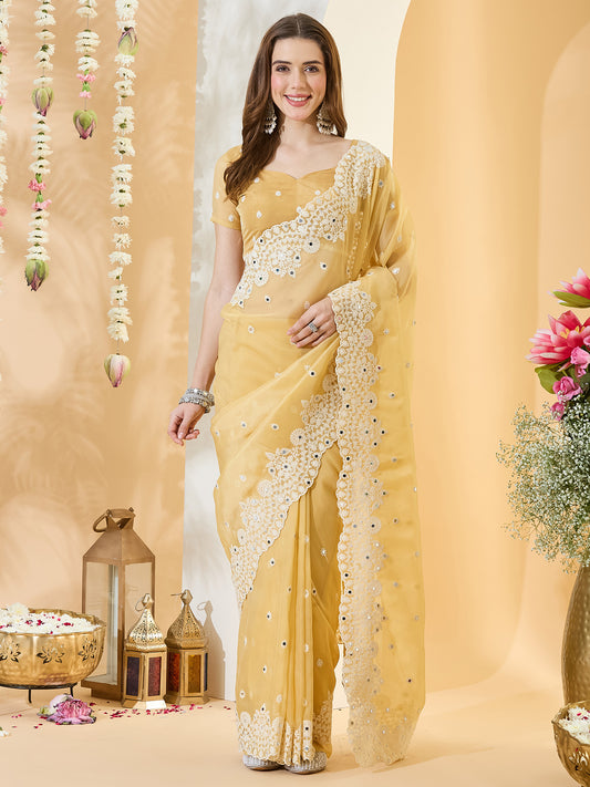Woman wearing yellow organza saree with embroidered motif work and yellow blouse