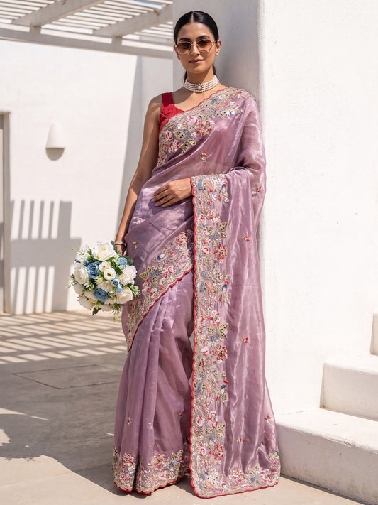 Woman wearing purple organza saree with embroidered motif work and red blouse
