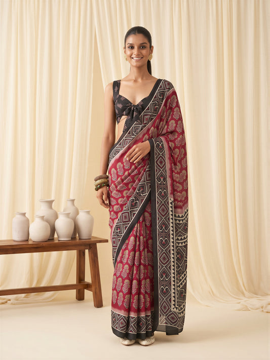 Woman wearing maroon satin saree with bagh block-print motif work and black blouse
