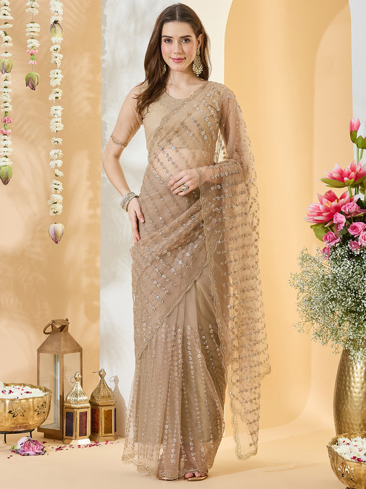 Woman wearing beige net saree with ornamented surface design and beige blouse