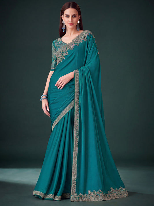 Woman wearing teal green pure chiffon saree with embroidered motif work and teal green blouse