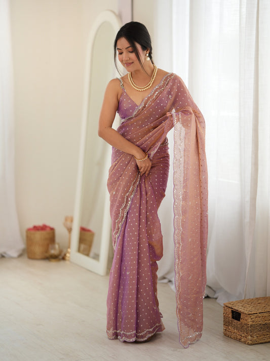 Woman wearing mauve georgette saree with zari butta (metallic motif) work and mauve blouse