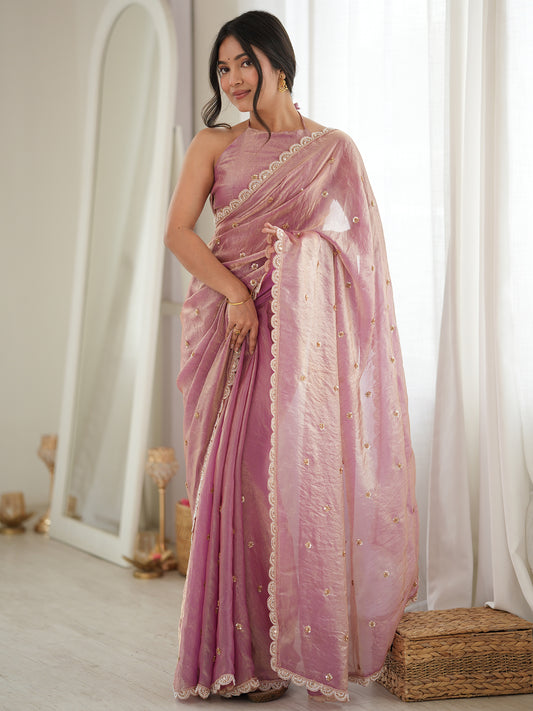 Woman wearing pink satin saree with ornamented surface design and pink blouse