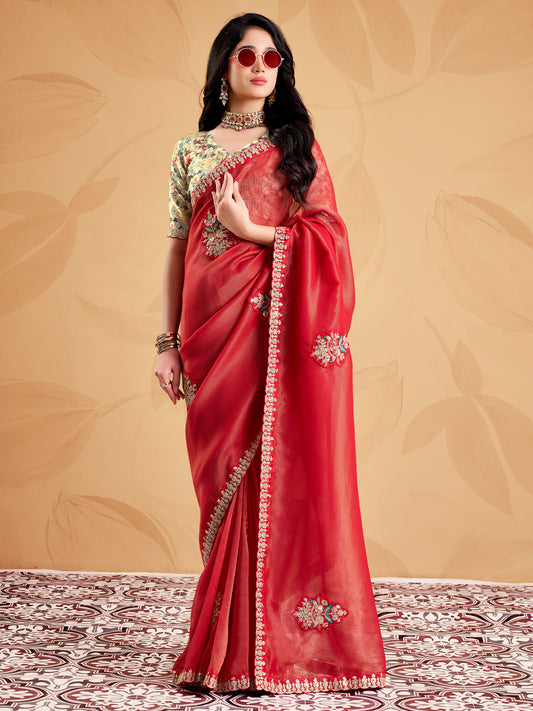 Woman wearing rust tissue saree with ornamented surface design and light green blouse