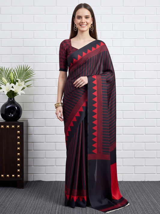 Woman wearing black satin saree with striped pattern design and black blouse