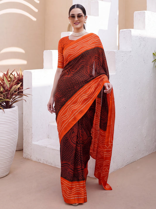 Woman wearing brown satin silk saree with bandhani tie-dye dot work and orange blouse
